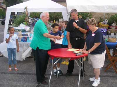 Father Chris Weber announcing raffle winners at the St Philomena rib off