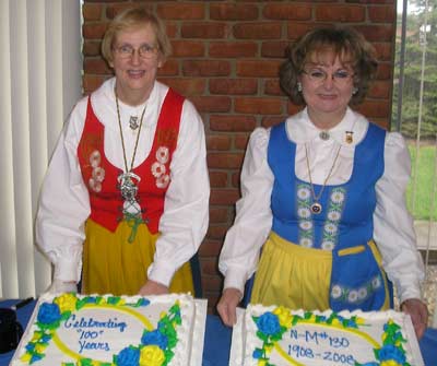 Marty Bergman and Karen Arvidson Chilcote with 100 Year Anniversary cakes