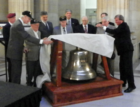 USS Cleveland crew members with ship bell