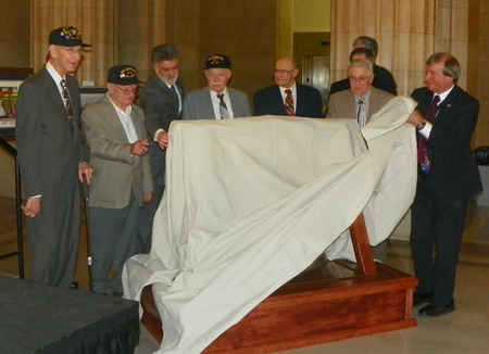 USS Cleveland crew members with ship bell