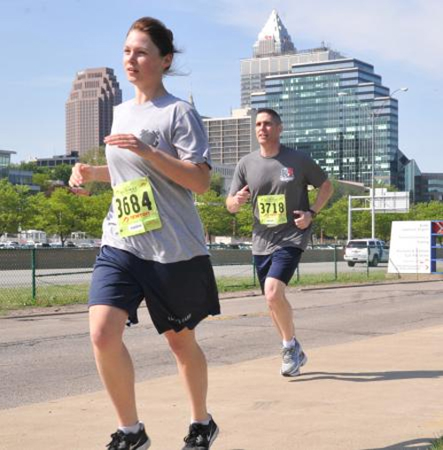 Seaman Sarah Molli, a member of Coast Guard Station Ashtabula, Ohio, and Master Chief Jeffrey Waters, a member of Coast Guard Base Cleveland, participate in the Run to Remember event held in Cleveland, May 17, 2013. In the event honoring those who have died saving lives, Molli placed first in her age group and first for females overall. 