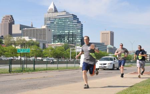 Lt. Michael Petta, a judge advocate in the 9th Coast Guard District legal department, waves to the camera as he participates in the Run to Remember event held in Cleveland, May 17, 2013. Units located at the Coast Guard Cleveland Mooring hosted Run to Remember, which is a run dedicated to remembering those who have died saving lives or defending freedom. (U.S. Coast Guard photo by Petty Officer 3rd Class Lauren Laughlin)