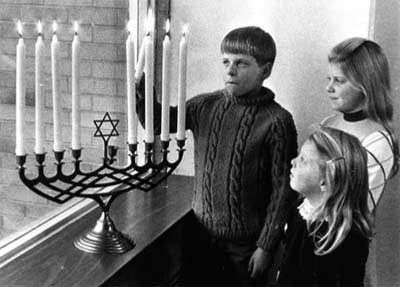 Rabbi Fred Eisenberg's children light the Menorah in 1968