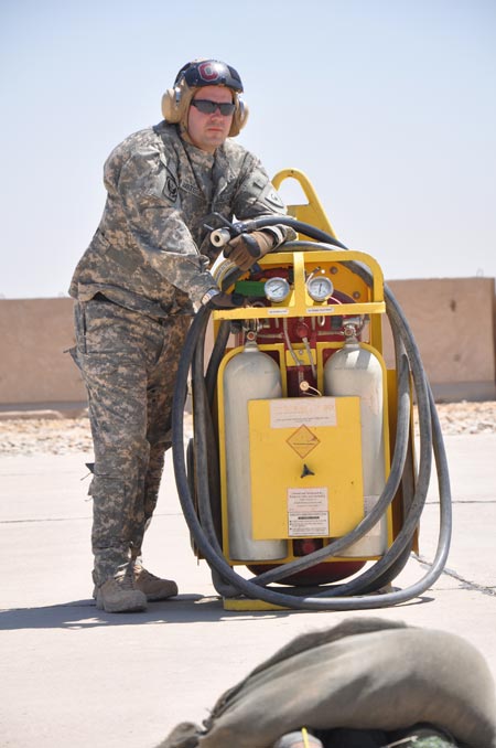 Ohio National Guard Spc. Thomas Masters, of Galloway, Ohio, and an aircraft refueler with Company E, stands guard next to fire extinguishers while a UH-60 Black Hawk helicopter is being refueled on Monday, August 24, 2009.