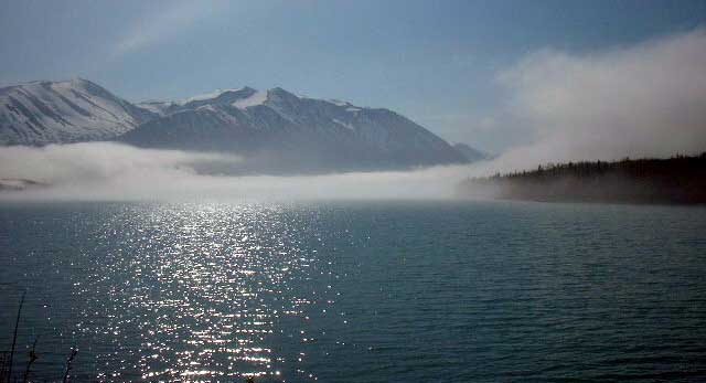Fog atop Kenai Lake backlit by sun