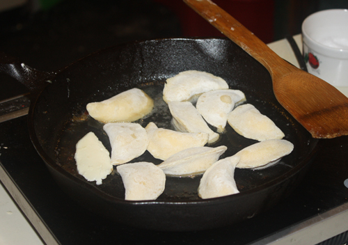 Pierogis frying in a pan