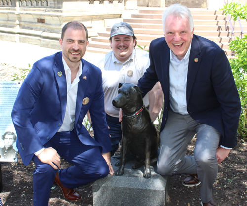 Chris Ronayne posing with Harvey the dog statue