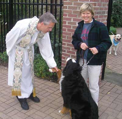Father Chris Weber greets Joan Atkian's dog Hub