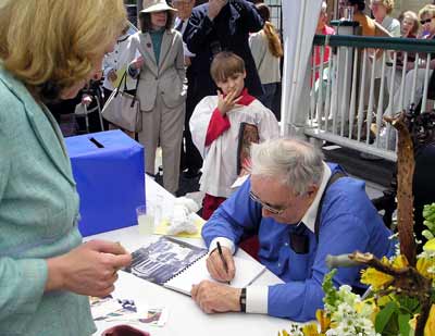 Father Mac signing copies of his book at his 50th anniversary celebration