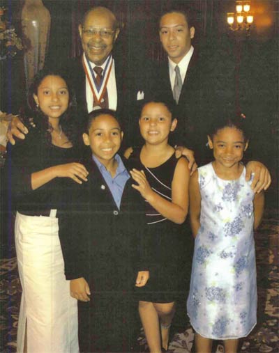 Louis Stokes receiving Congressional Distinguished Service Medal, with Eric Hammond (grandson), and front row from left grandchildren Alexandra Thompson, Grand Hammond, Nicolette Thompson, and cousin Dacia Johnson