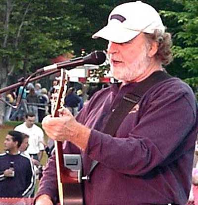 Pat Dailey on stage playing guitar and singing