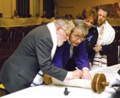Rabbi Fred Eisenberg inscribes a letter  in Temple Israel Ner Tamid's new Torah